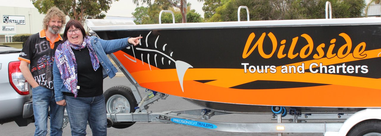 Black and orange boat wrap with company logo and graphics in dureable digital printed vinyl, suitable for use in the sun and salt water