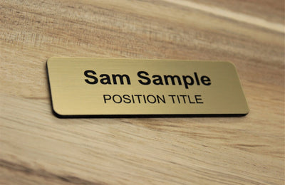 Brushed gold name tag with coloured logo, name and title in standard 75x25mm size
